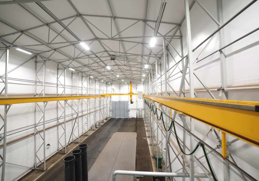 Automated biomass fuel sampling facility equipped with bridge crane sampling systems and sample handling infrastructure.